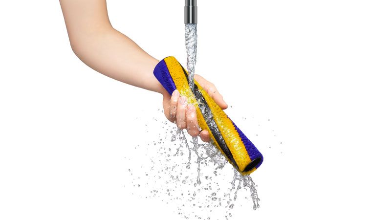 Dyson V15 vacuum attachment being cleaned under faucet